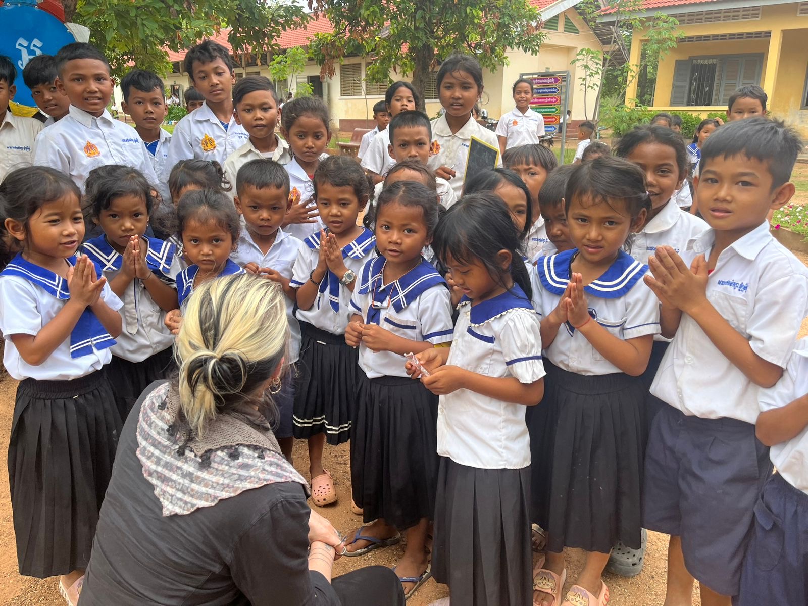 Arwa Damon greeting Cambodian schoolchildren in a rural village