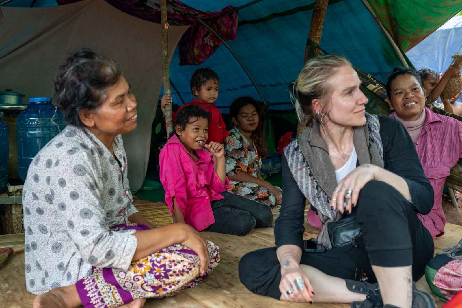Arwa Damon sitting with Cambodian families inside a shelter, listening
